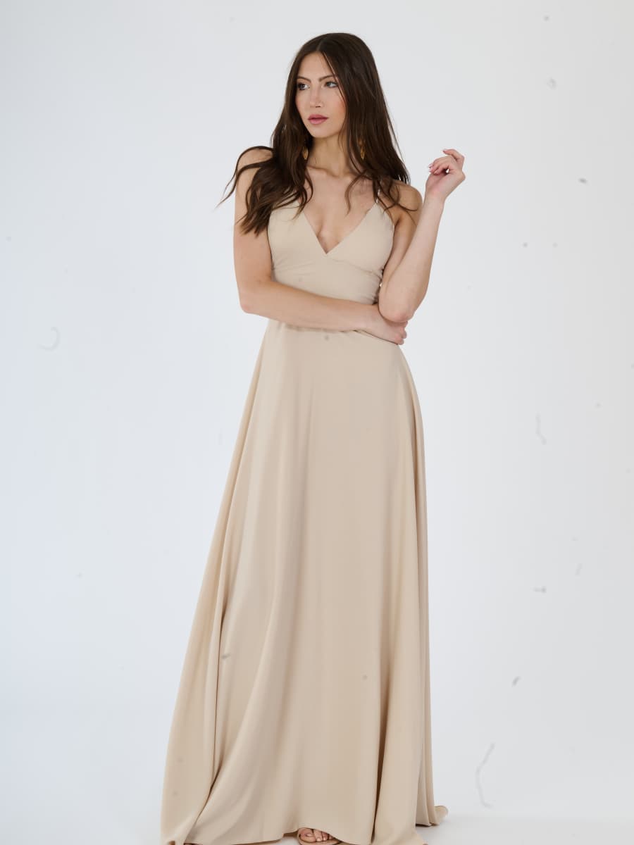 Abito lungo beige minimalista con spalline sottili, perfetto per un look elegante.
