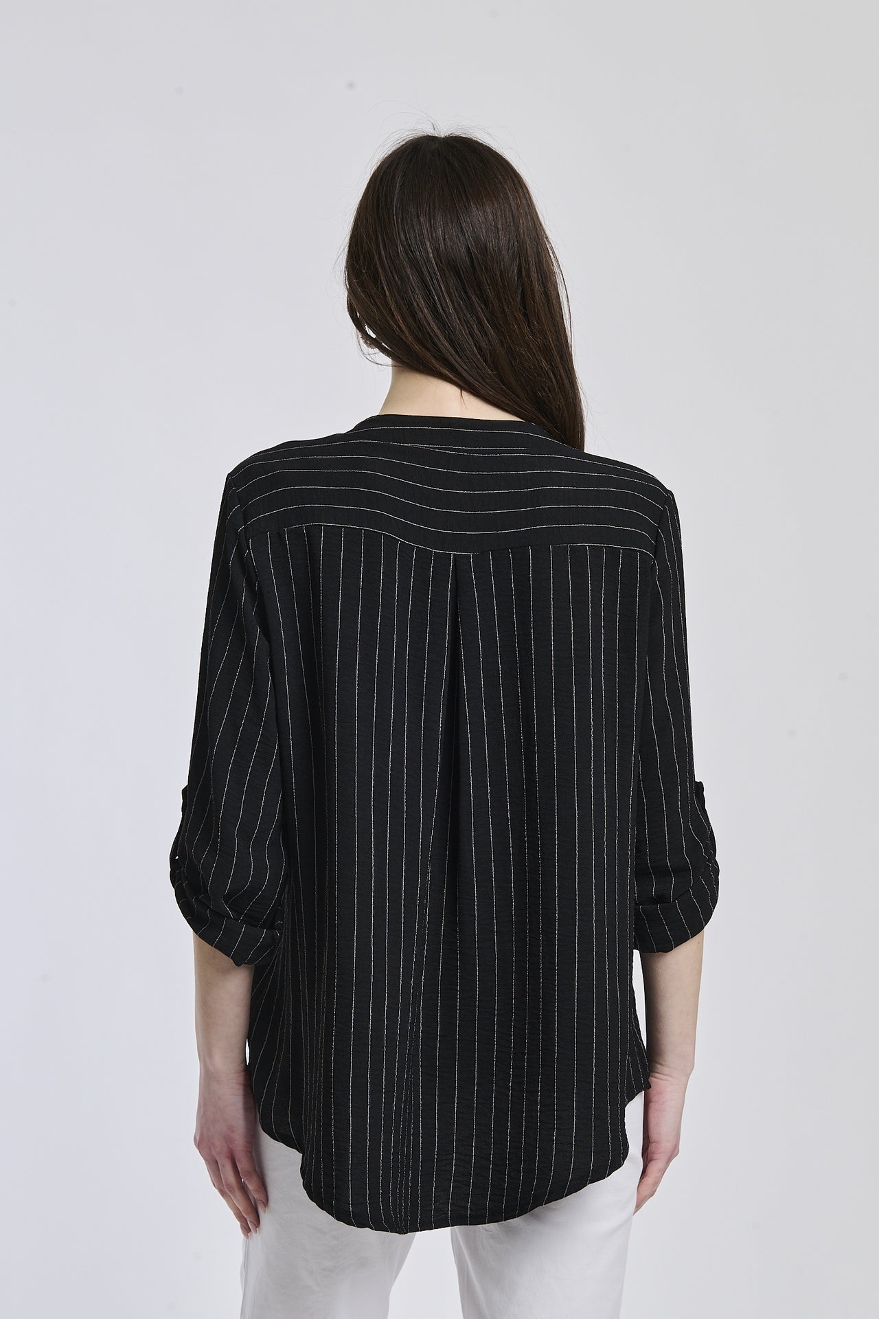 Camicia nera in tessuto opaco, due tasche frontali, abbinata a fondo chiaro