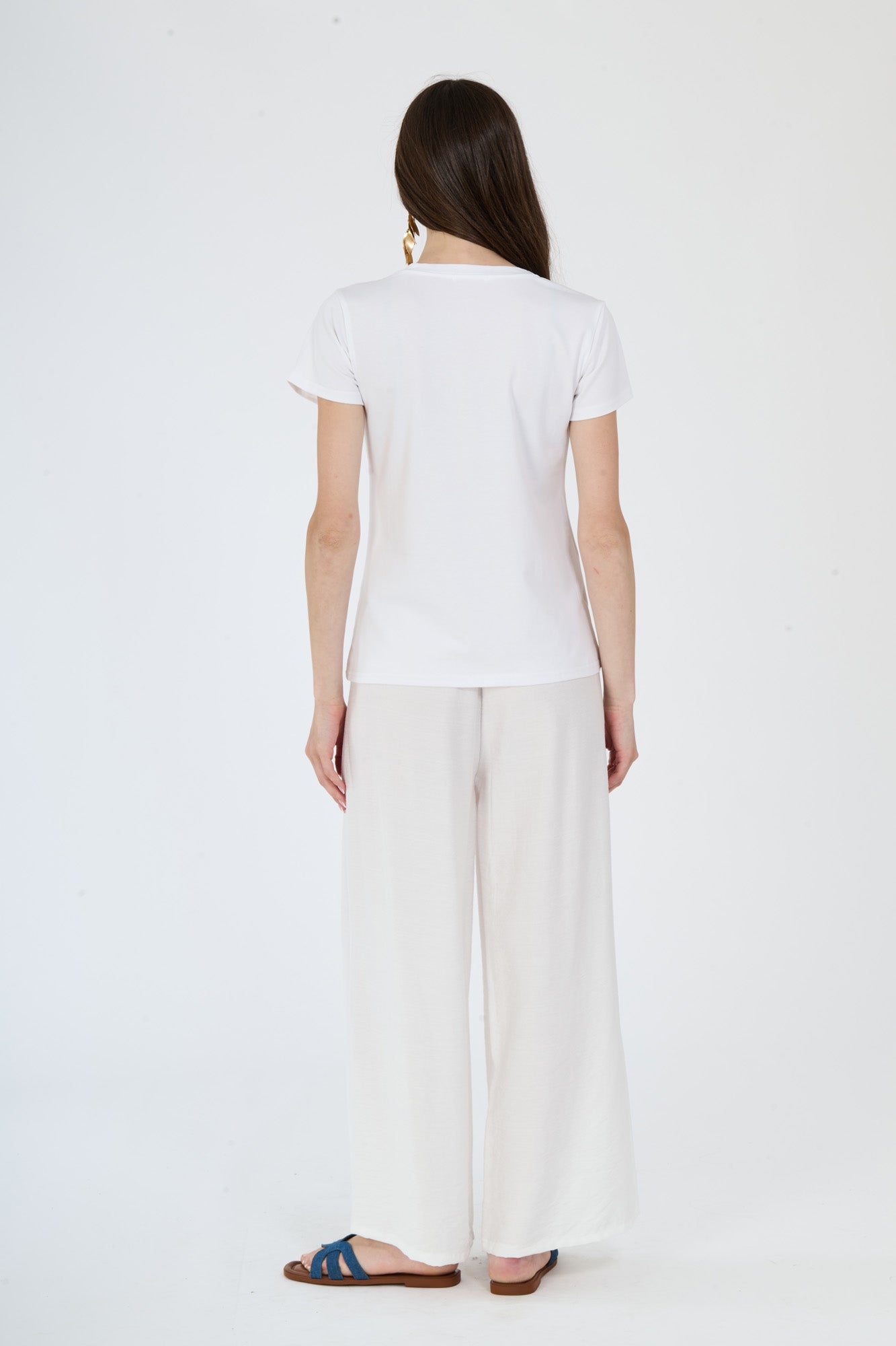 Completo bianco da giorno: t-shirt e pantaloni indossati da una modella