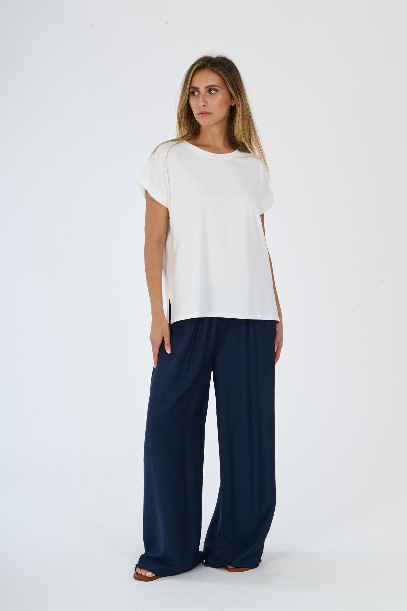 Donna in abbigliamento beige: t-shirt a maniche corte e pantaloni fluidi