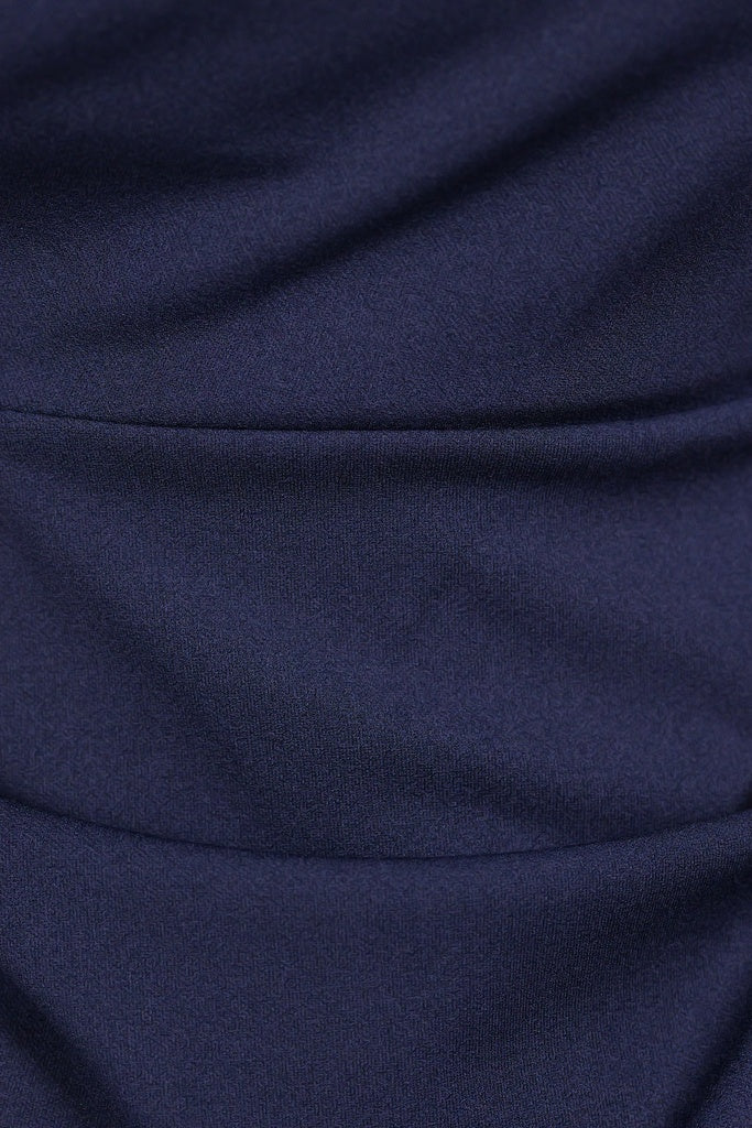 Donna indossa un abito navy senza maniche, lunghezza midi, con nodo al petto, look elegante.