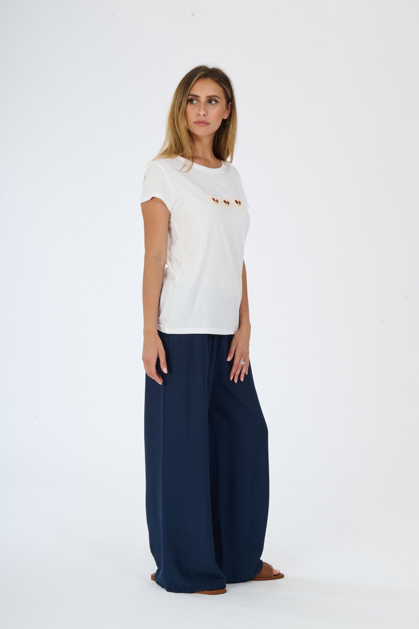 Donna indossa un look beige composto da t-shirt e pantaloni larghi