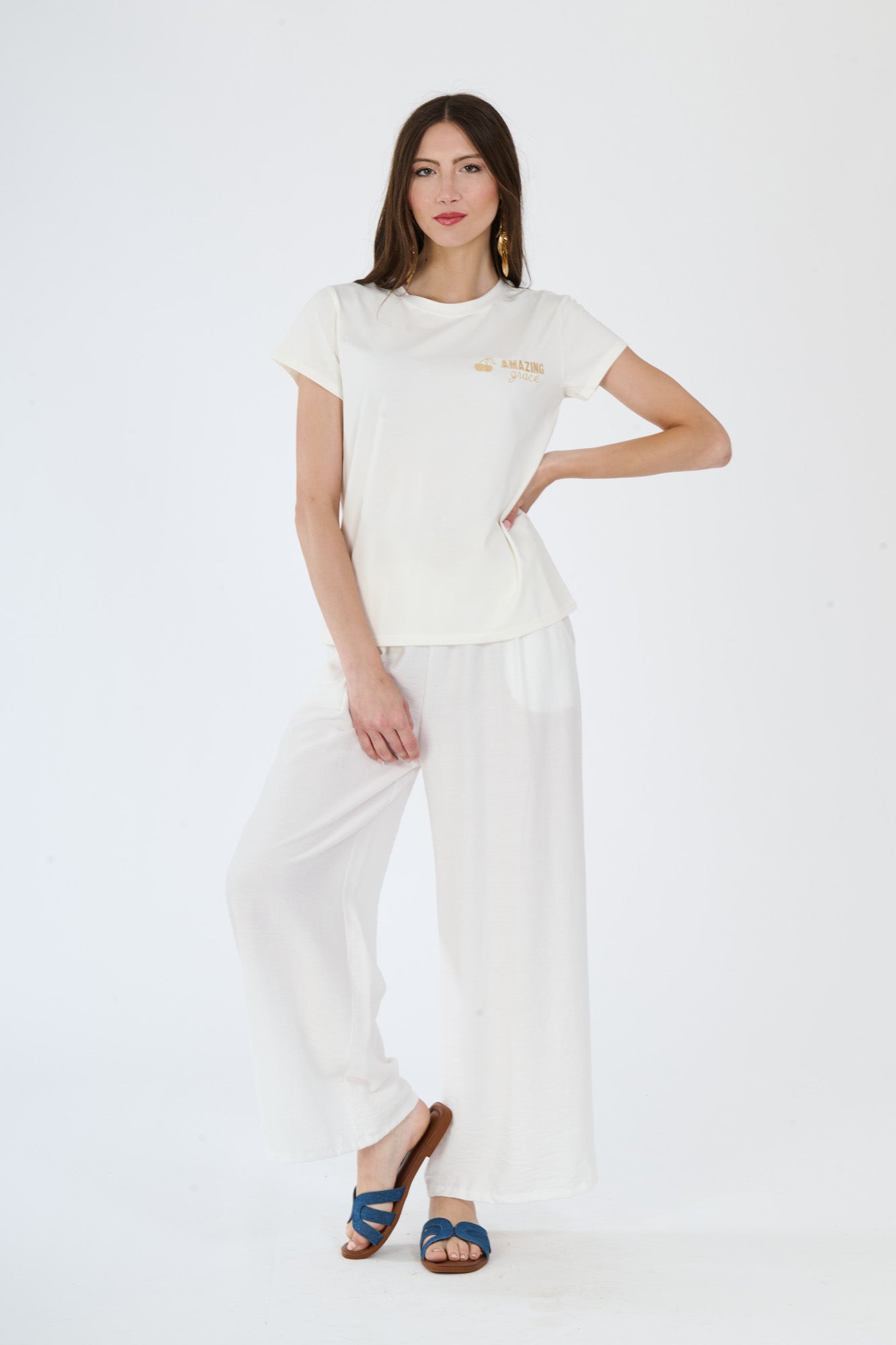 Donna indossa un outfit bianco composto da t-shirt e pantaloni fluidi