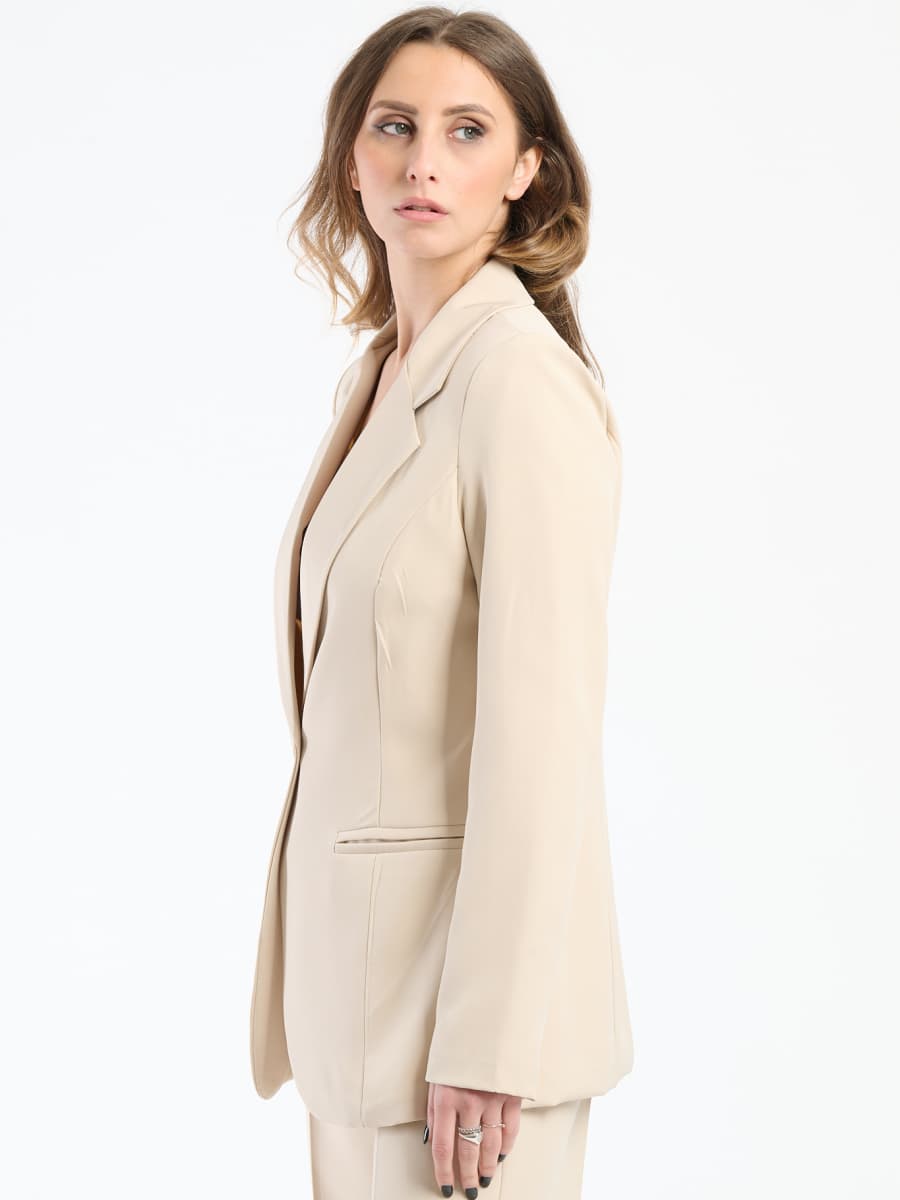 Ensemble beige: blazer con bottoni e pantaloni, stile sofisticato per la donna moderna.