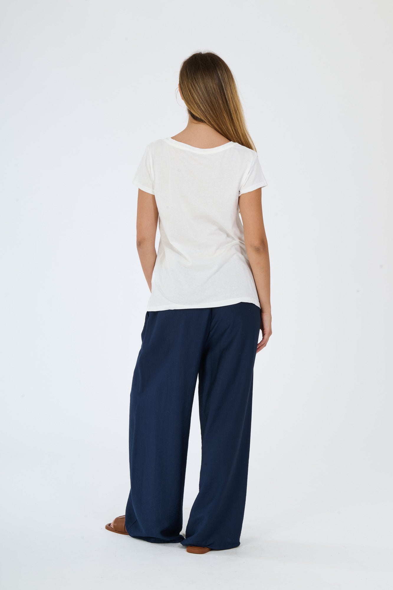 Modella in abbigliamento beige: t-shirt a maniche corte e pantaloni fluidi
