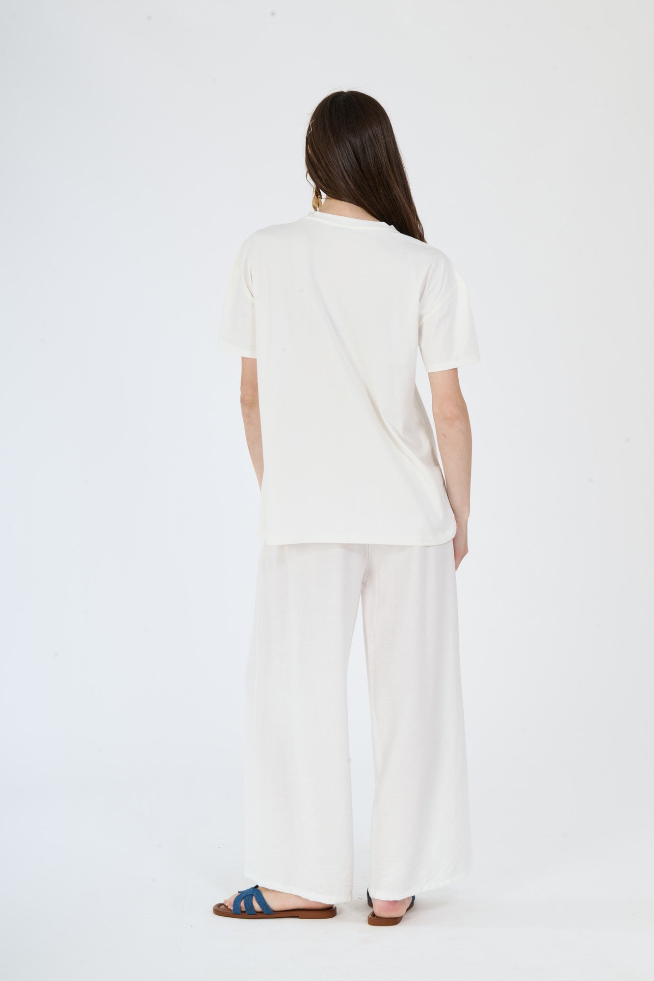 Modella in completo bianco: t-shirt a maniche corte e pantaloni ampi