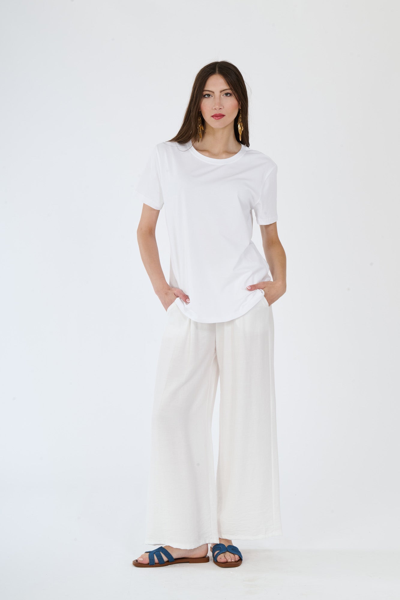 Outfit bianco minimalista: t-shirt e pantaloni larghi su una persona