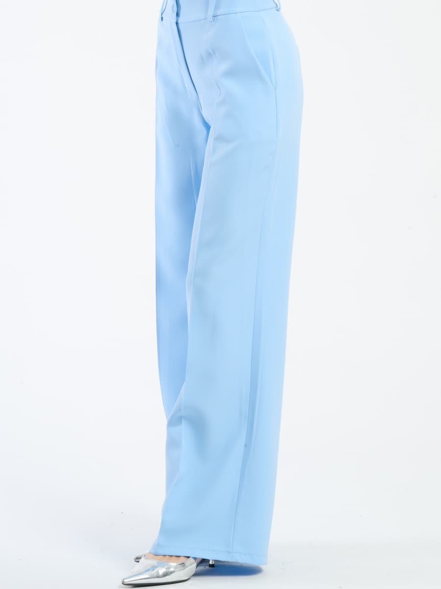 Pantaloni azzurri fluidi con chiusura a bottoni, ideali per l’estate.