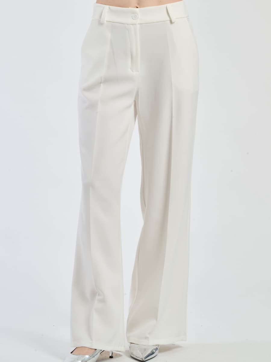 Pantaloni larghi bianchi con pieghe frontali, luminosità e purezza stilistica.
