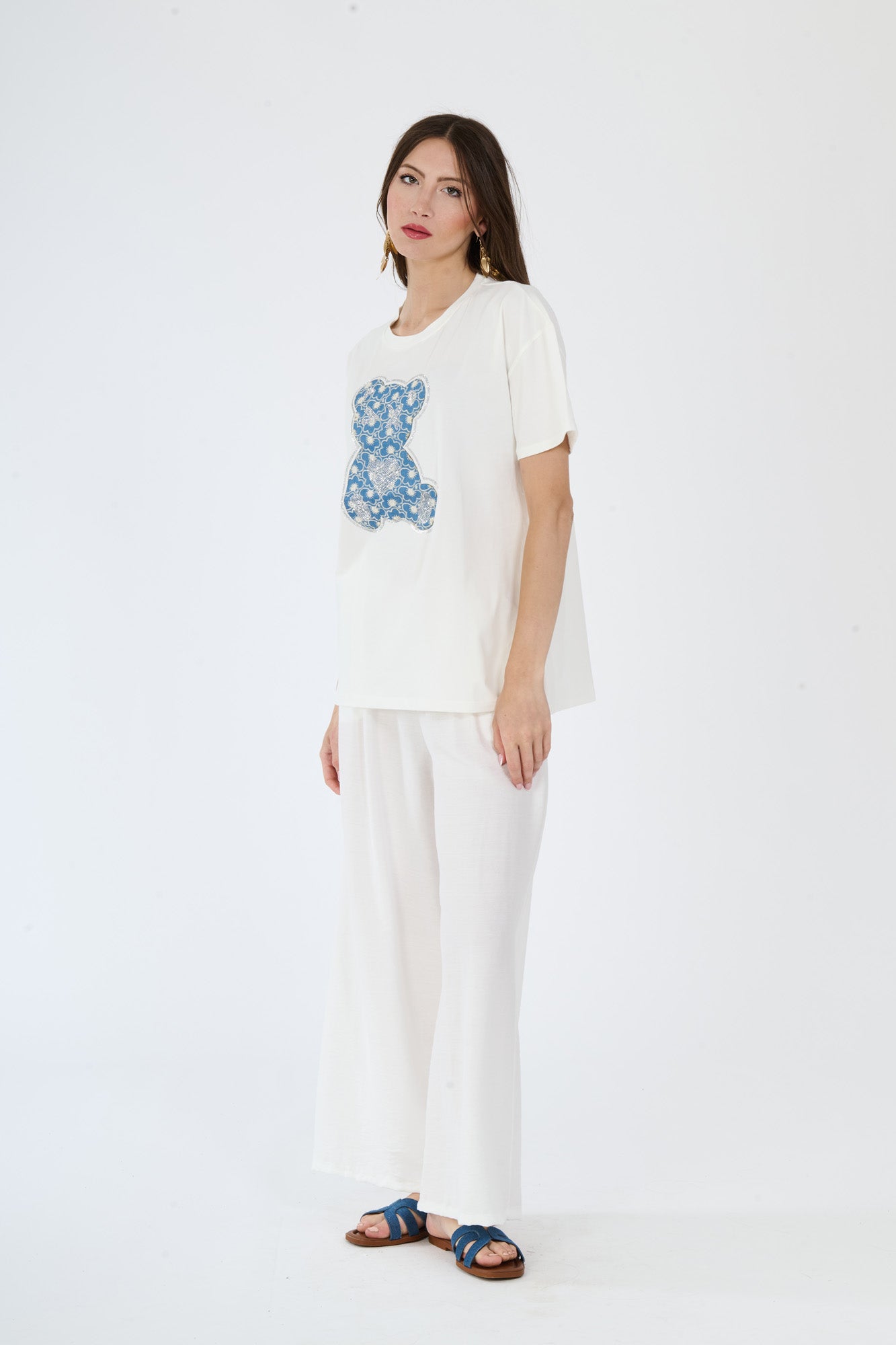 T-shirt bianca con scritta e pantaloni bianchi larghi indossati da una moda