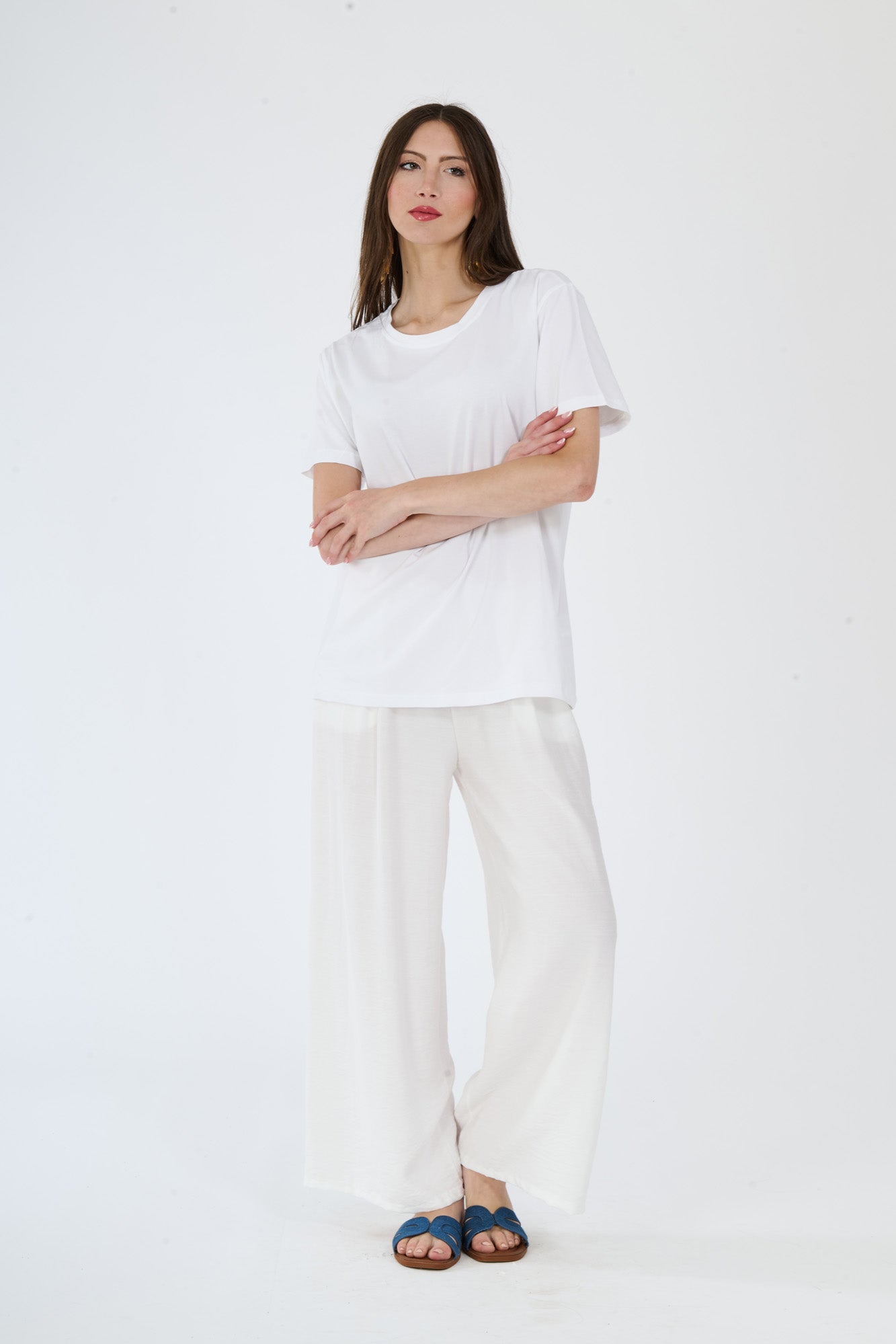T-shirt bianca stampata e pantaloni bianchi larghi su una figura femminile