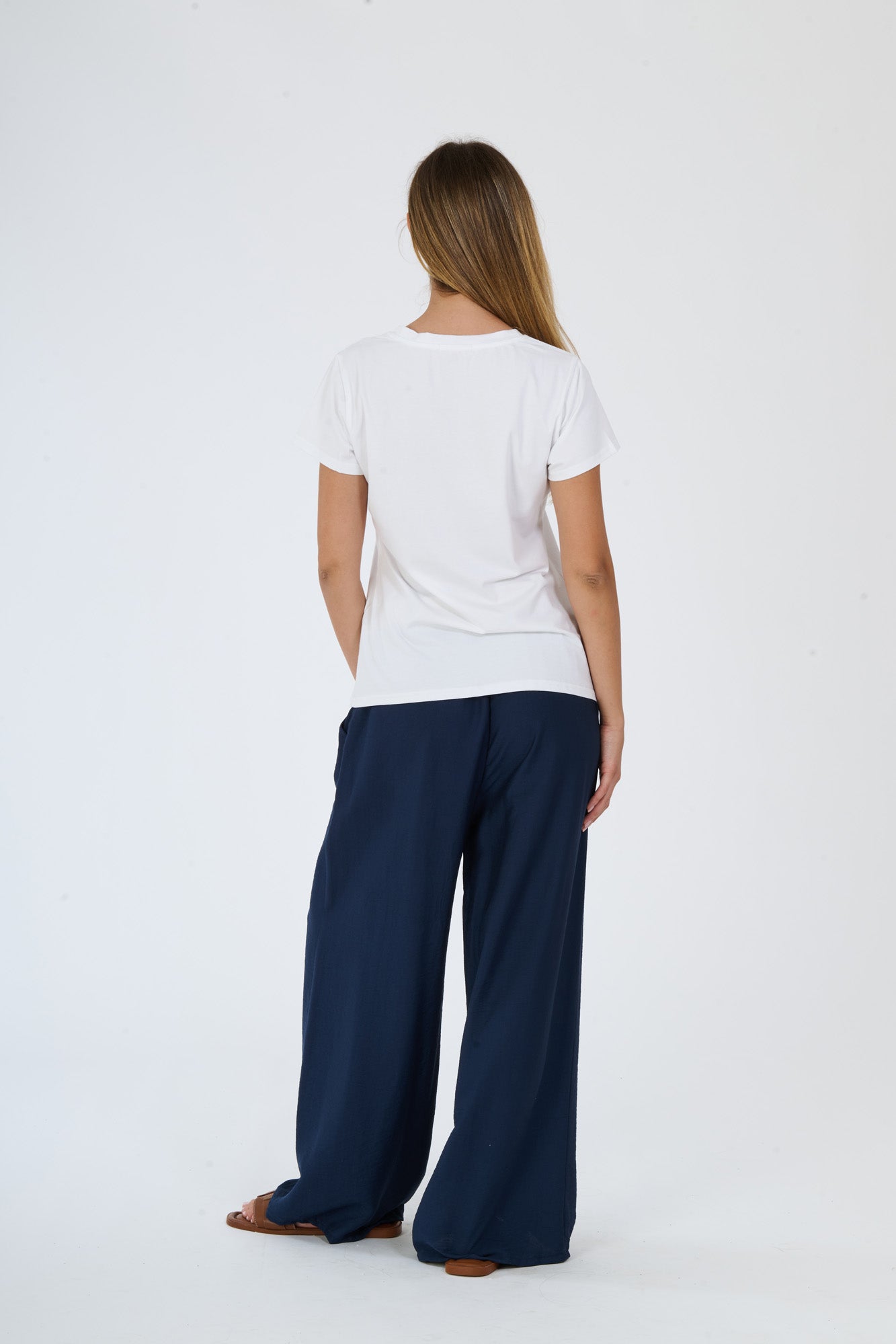T-shirt bianca stampata e pantaloni scuri larghi su una donna elegante