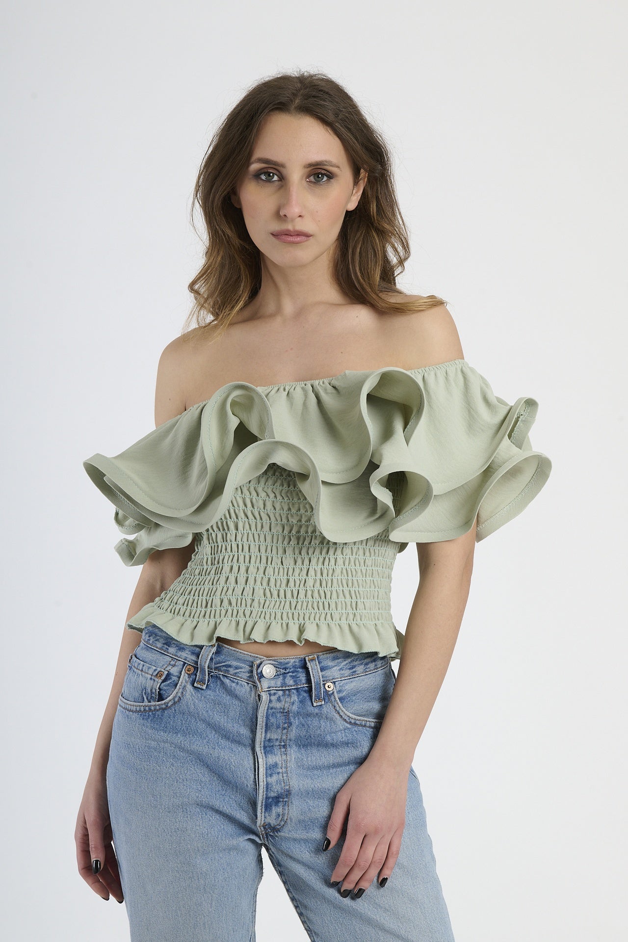 Top salvia a spalline nude con rouches sul busto, abbinato a jeans.