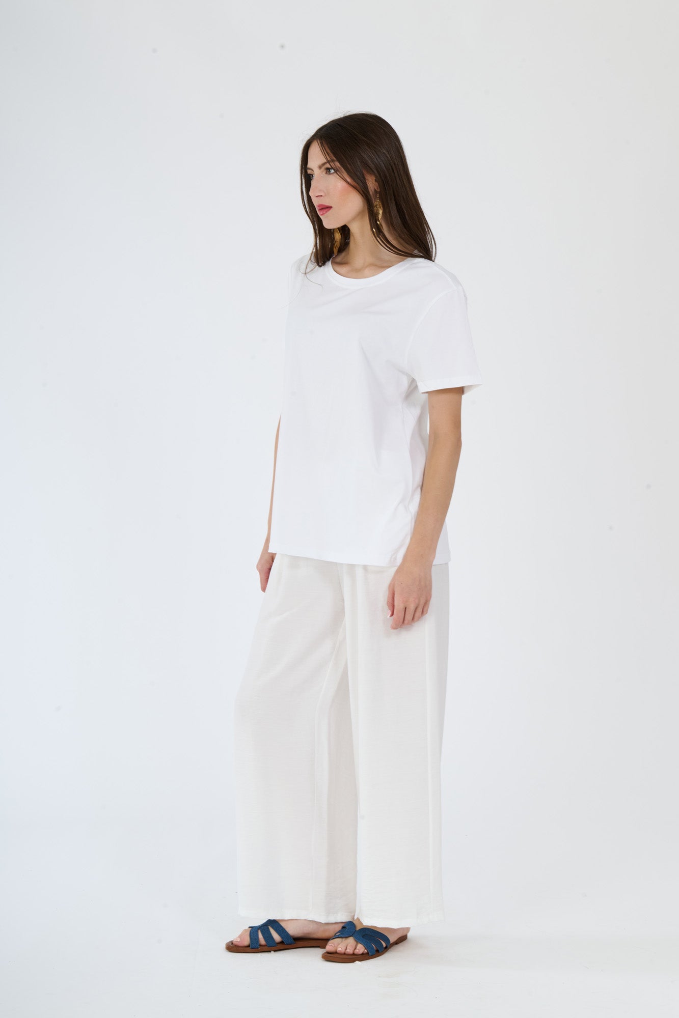 Donna in abbigliamento bianco: t-shirt a maniche corte e pantaloni fluidi