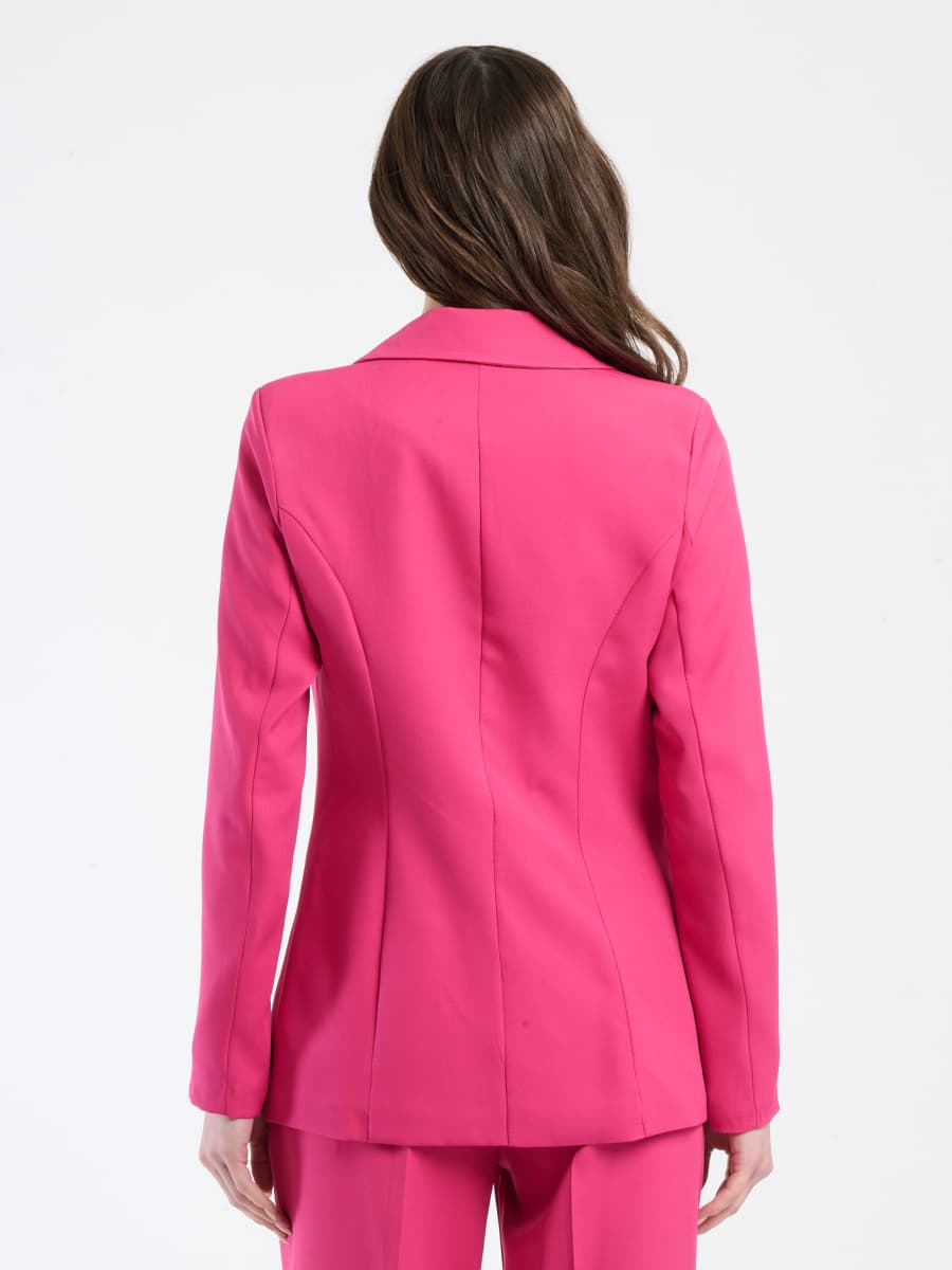 Outfit fuxia in tessuto stretch, blazer formoso e pantaloni, perfetto per attirare l’attenzione.