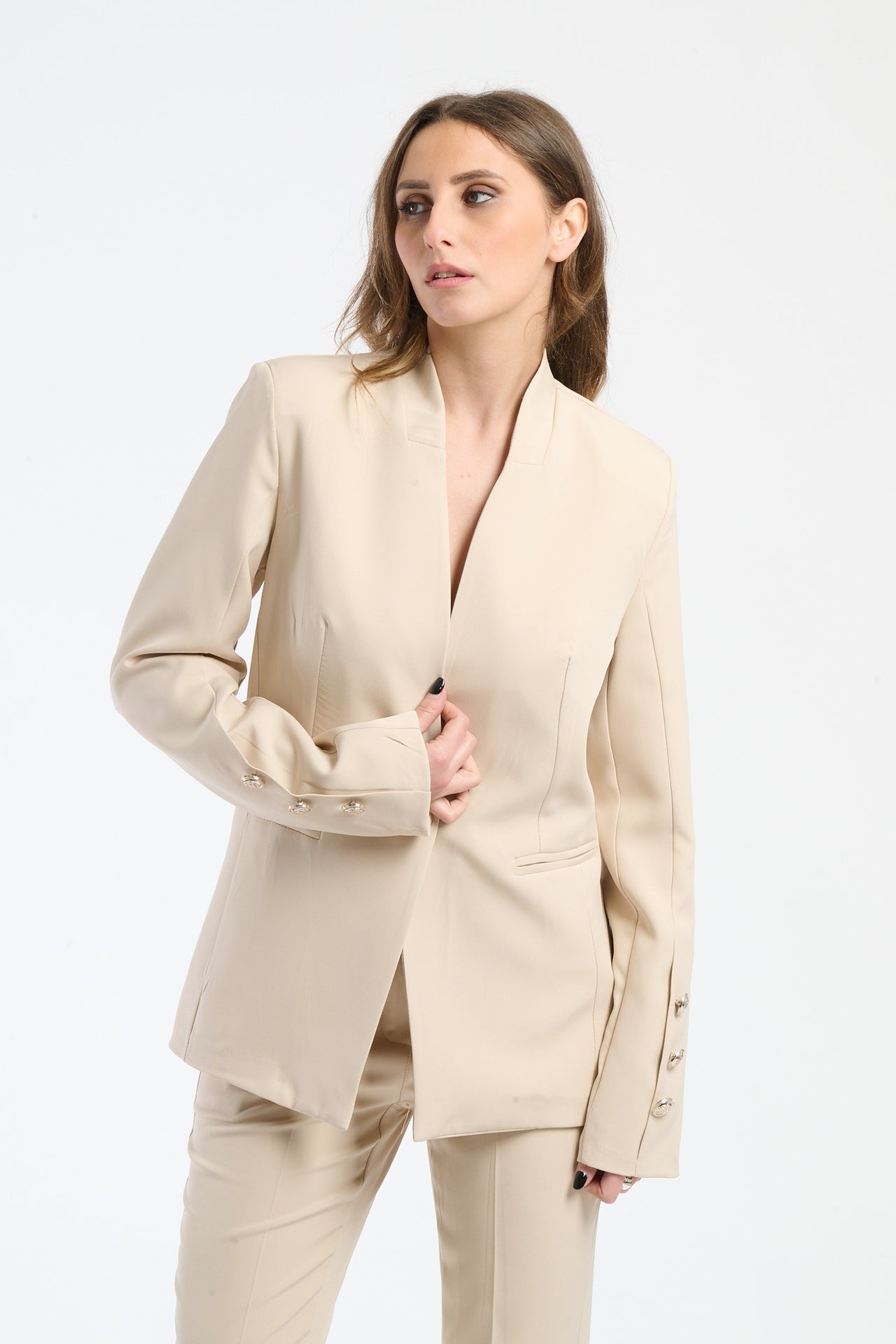 Camicia beige con collo a pennello e bottoni decorativi.