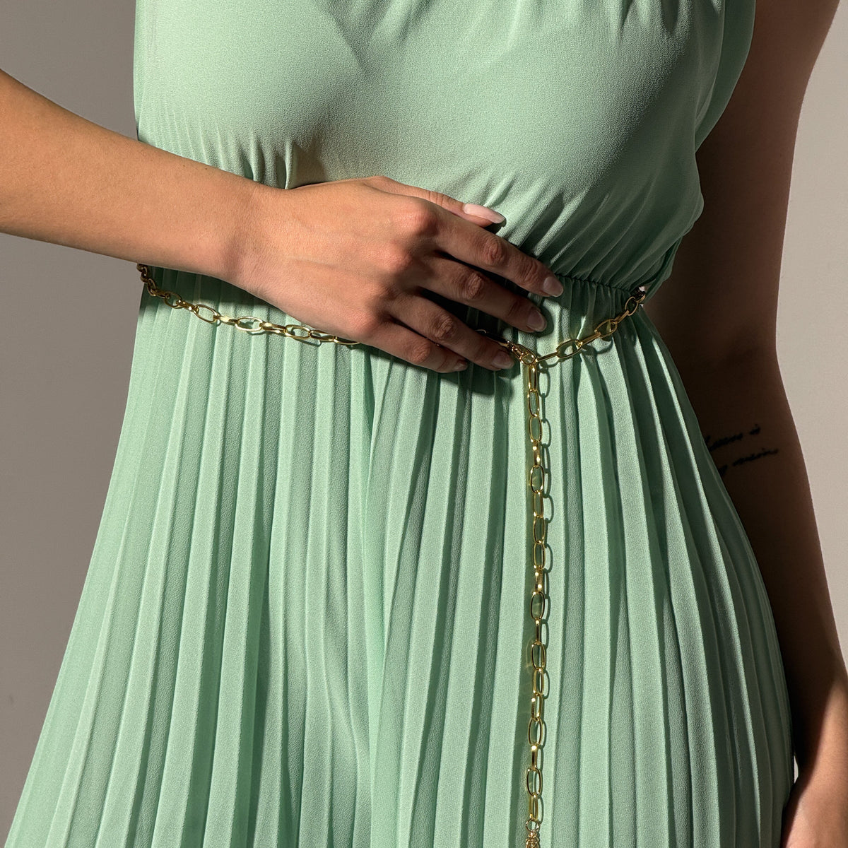 Jumpsuit verde menta con colletto a scollo alto, stile minimale ed elegante.