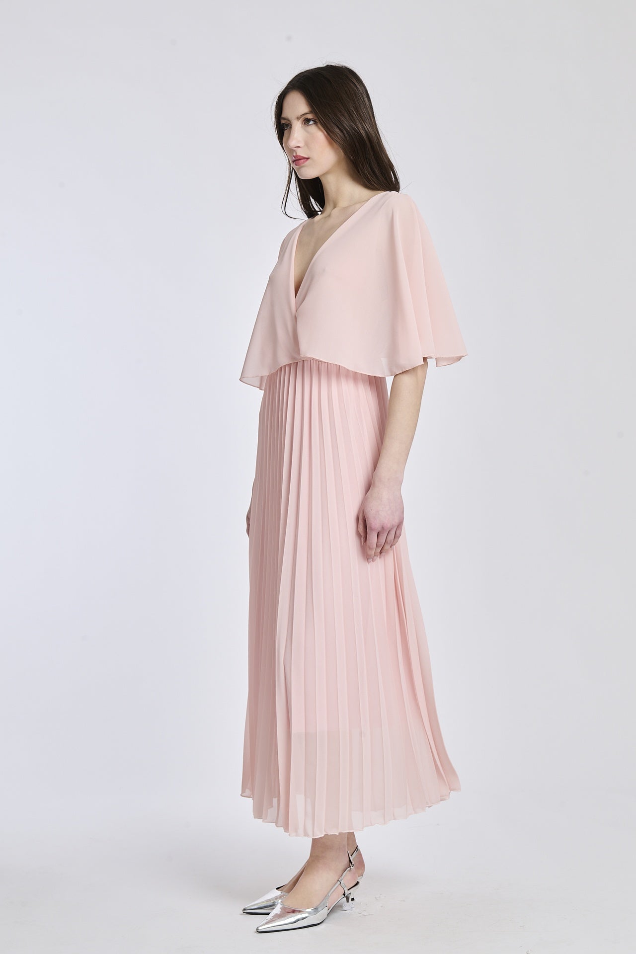 Vestito in tono rosa chiaro con dettagli di falde e maniche, offrendo un look accattivante e romantico.