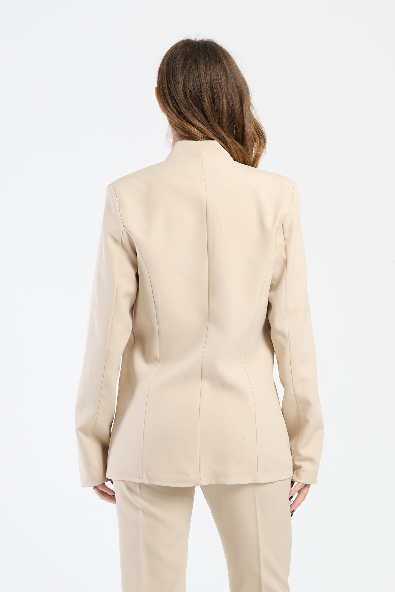 Donna indossa una camicia beige aderente con dettagli in seta.