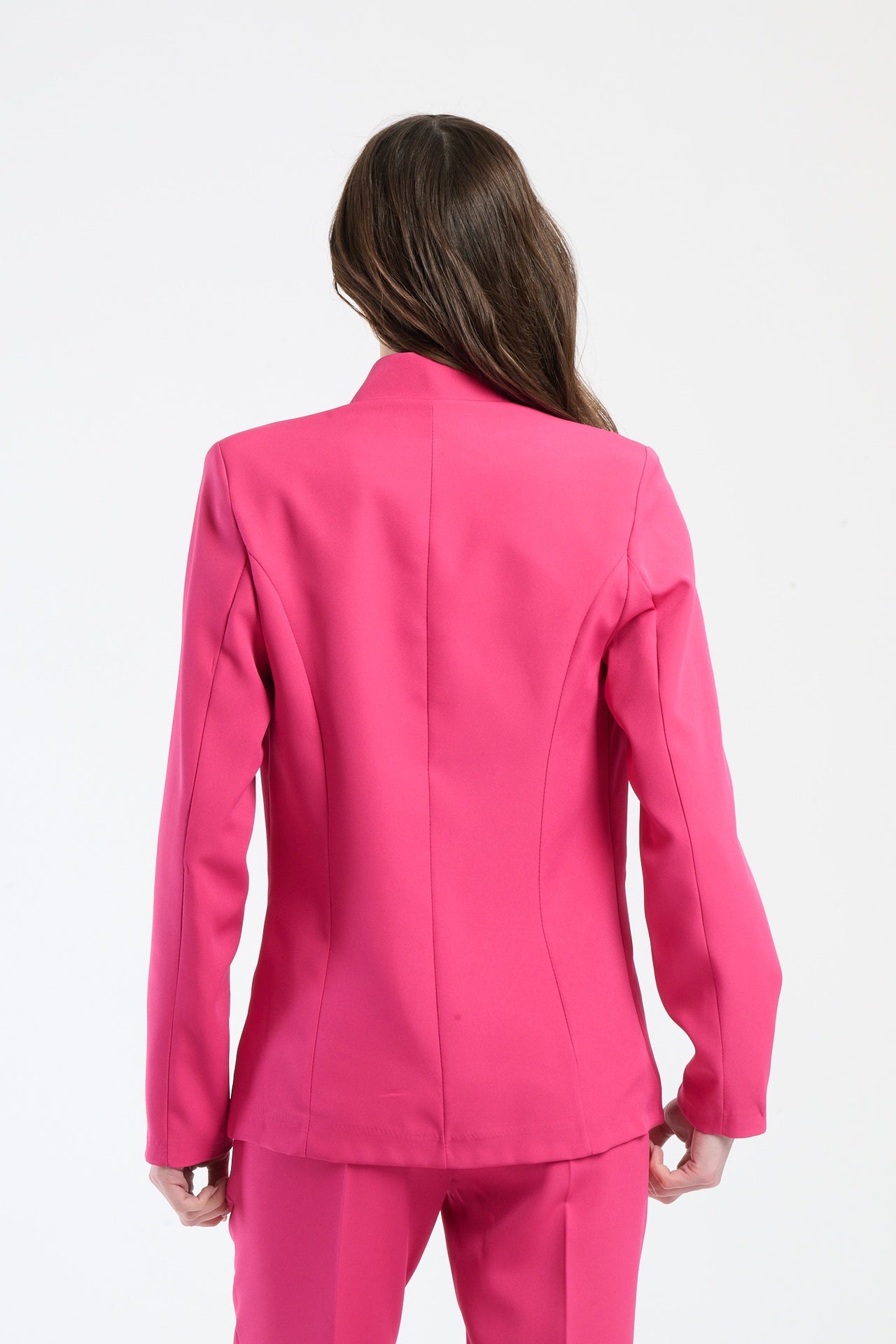 Donna in camicia fuxia aderente con dettagli di cucitura.