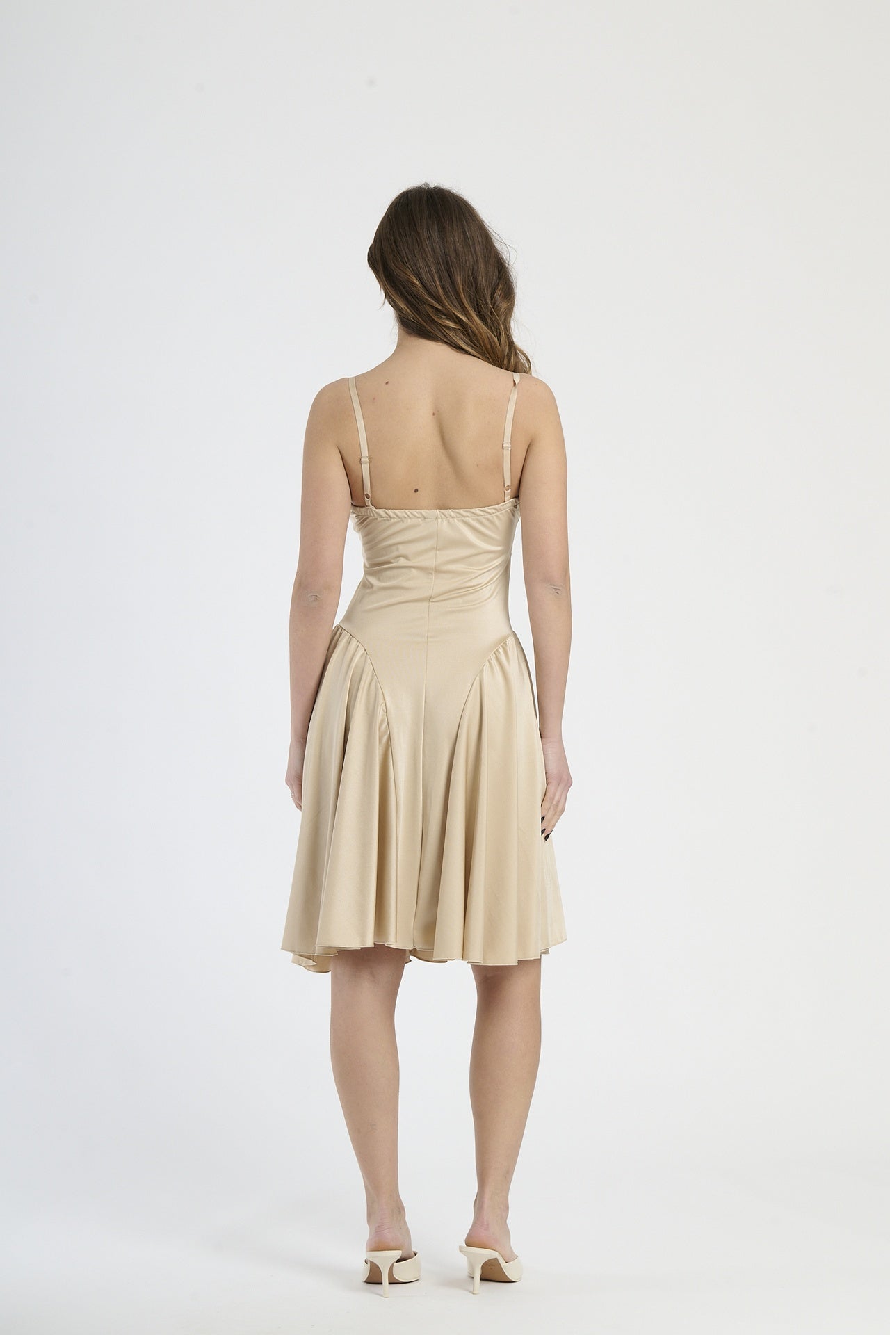 Modella in abito beige, stile classico e versatile.