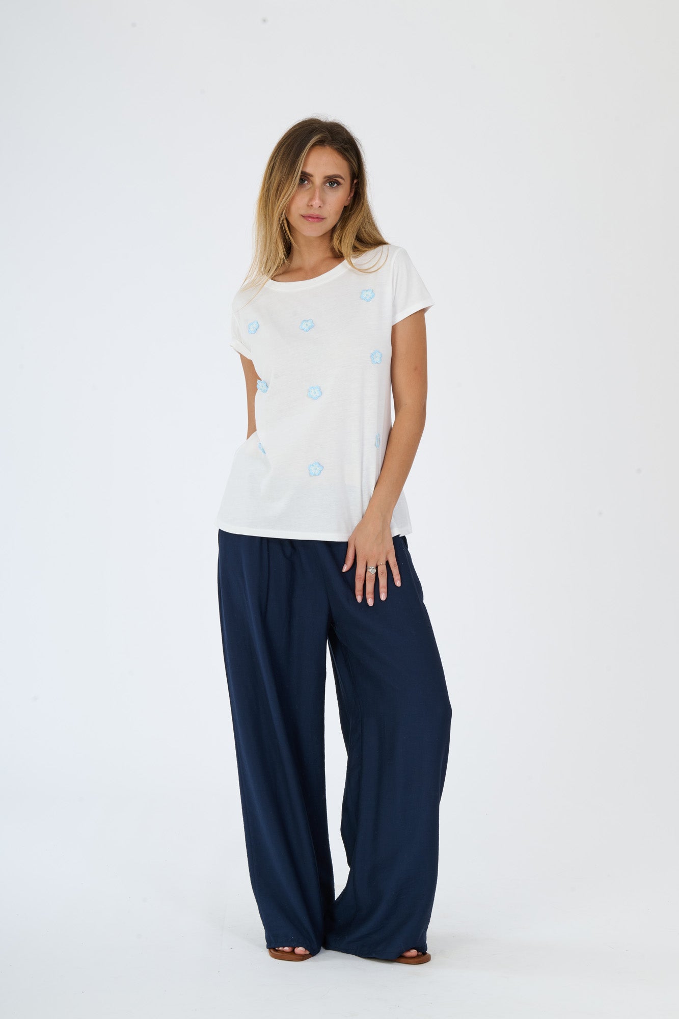 Outfit di stile quotidiano e confortevole: maglietta bianca a pois e pantaloni larghi scuri, esibizione di uno stile fashion rilassato