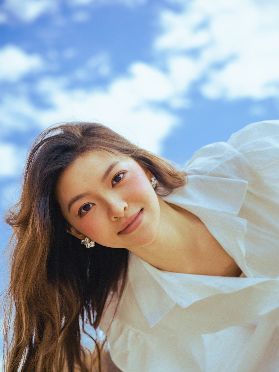 Vestito bianco a camicia con maniche a bufala, silhouette fluida per un’eleganza leggera.