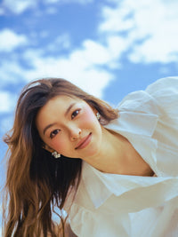 Vestito bianco a camicia con maniche a bufala, silhouette fluida per un’eleganza leggera.