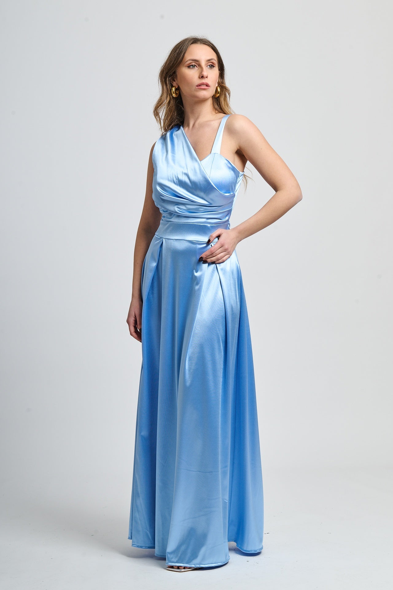 Abito azzurro in tessuto satinato, spalliera singola e drappeggiato sul busto.