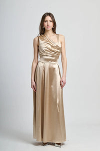 Abito beige in tessuto satinato, spalliera singola e drappeggiato sul busto.