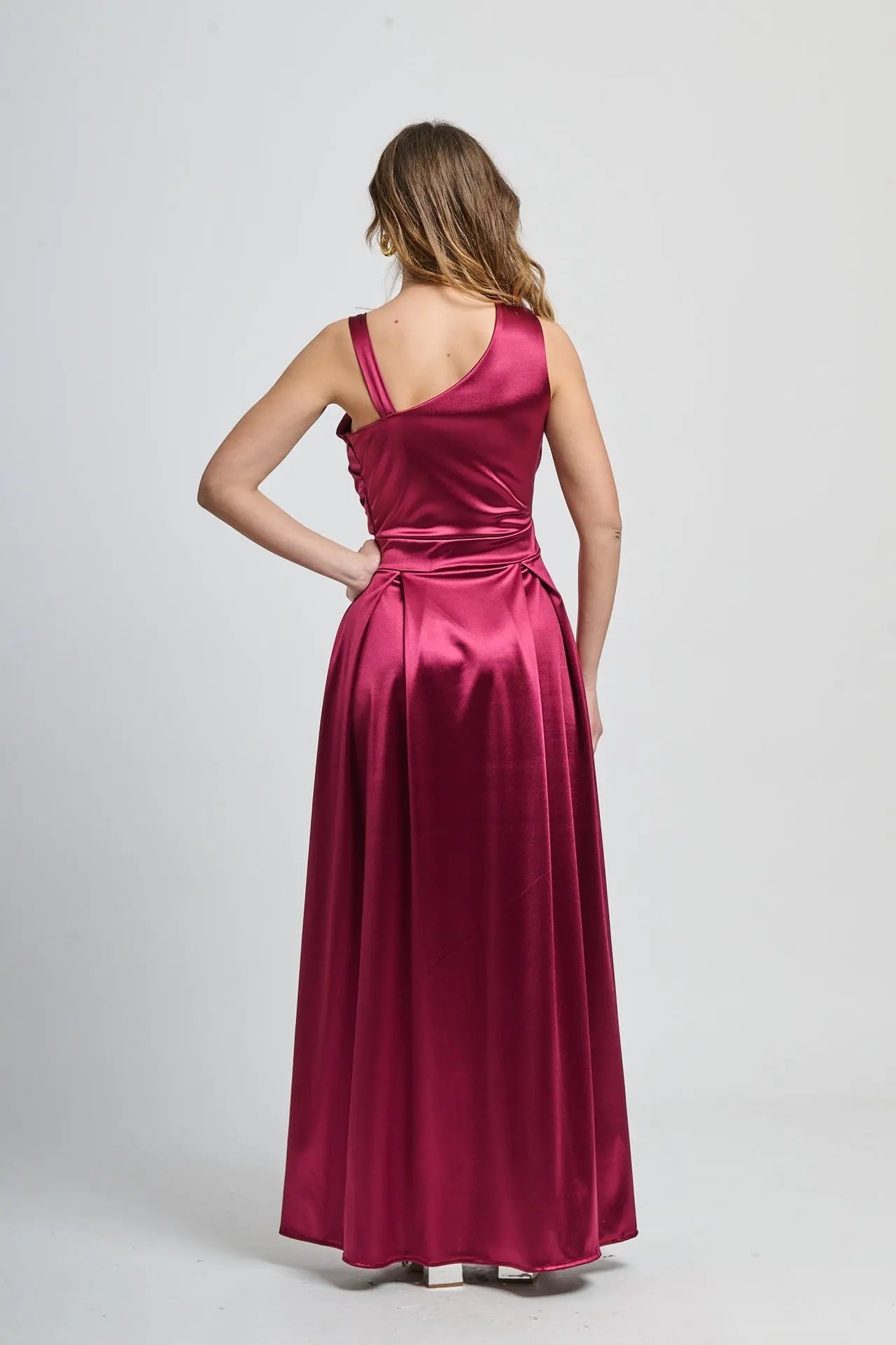 Abito bordo profondo con taglio asimmetrico, perfetto per serate glamour.