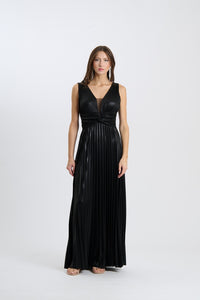 Abito da sera nero lungo, senza maniche, con plissé e scollatura a V, indossato da una donna in posa classica.
