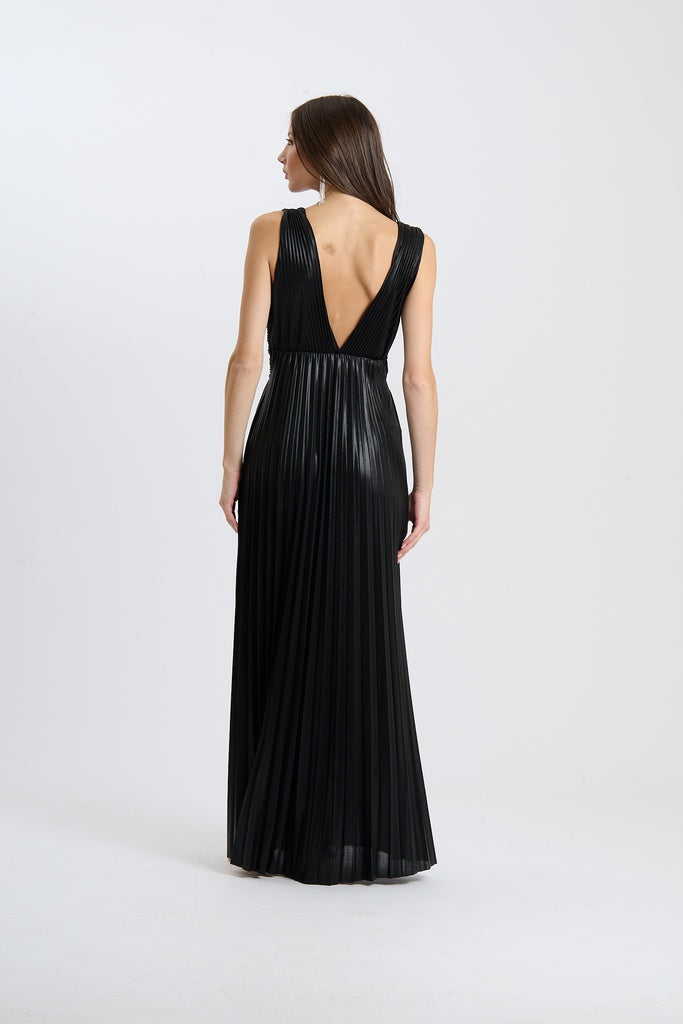 Abito da sera nero, stile lungo senza maniche, plissé e scollatura a V, indossato da una donna.