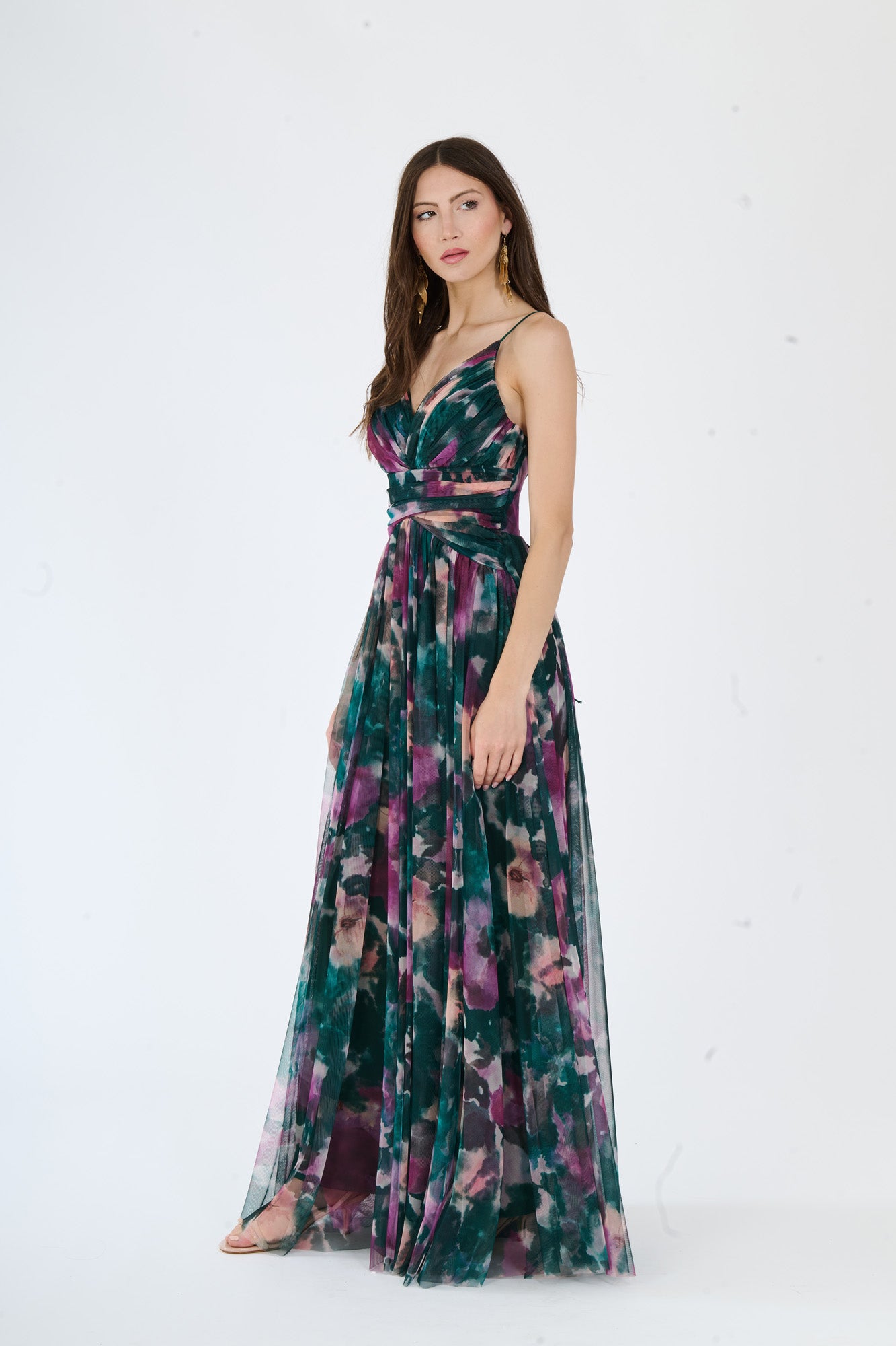 Abito elegante verde scuro con decolleté a V, fascia vita e stampa multicolore, indossato da una ragazza