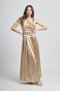 Abito lungo beige in seta, spalliera asimmetrica e fascia vita definita.