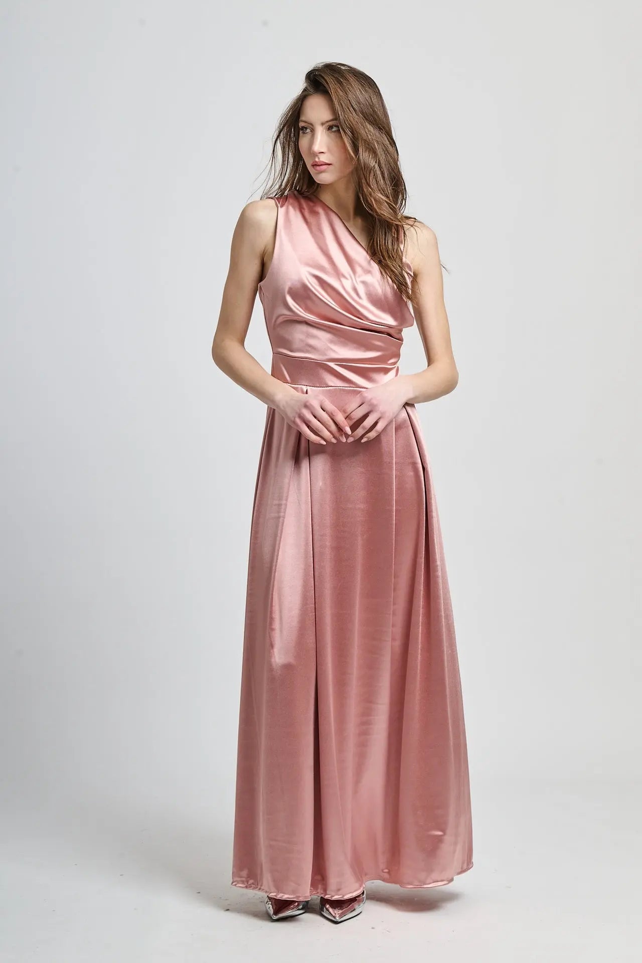 Abito lungo rosa antico in seta, spalliera asimmetrica e fascia vita definita.