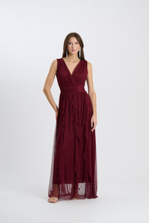 Abito lungo senza spalline di colore vino, scollatura a V incrociata, gonna flusso con tessuto trasparente, ideale per serate formali o matrimoni.