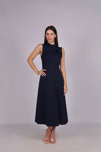 Abito navy da donna, senza maniche, lunghezza midi, dettaglio nodo sul petto, stile professionale ed elegante.