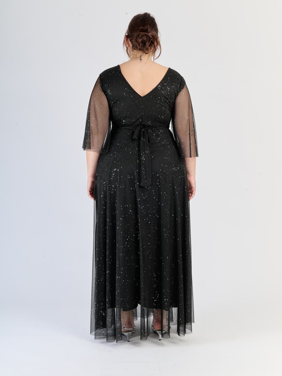 Abito nero da cerimonia, flusso e con maniche traslucide, incarna il lusso nero.