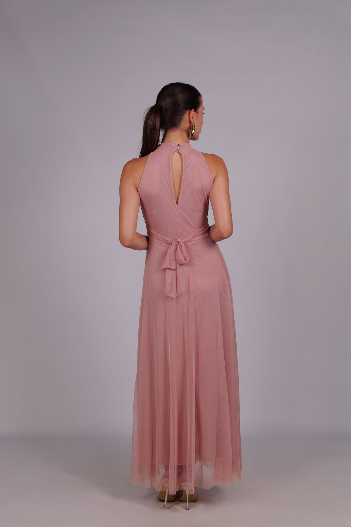Abito rosa da donna, collo alto a imbarcatura, gonna lunga, accessoriato con foulard in tulle, stile elegante e romantico.