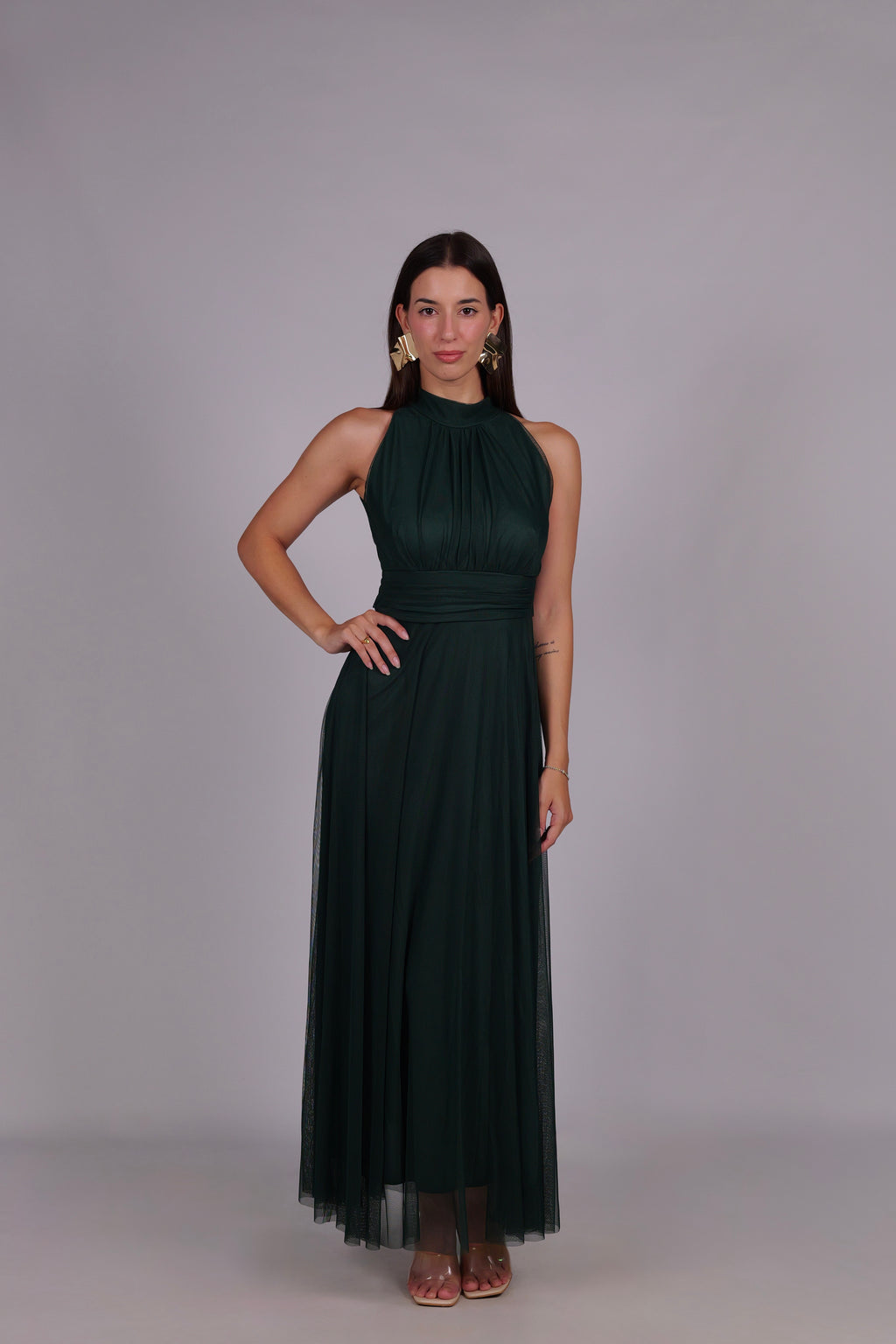 Abito verde scuro da donna, collo alto a imbarcatura, gonna lunga, foulard in tulle, stile elegante e con carattere.