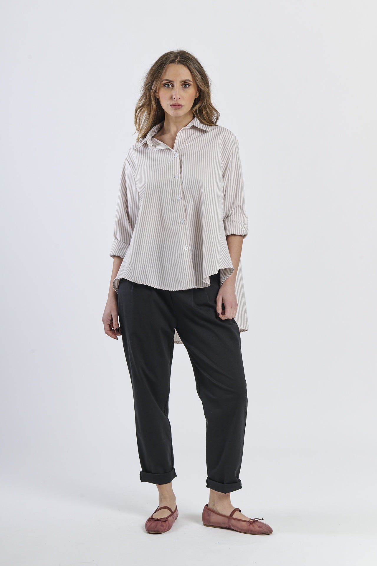 Camicia a righe beige, abbinata a pantaloni neri, stile casual