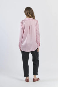 Camicia rosa fluida e dolce, maniche lunghe e design romantico.