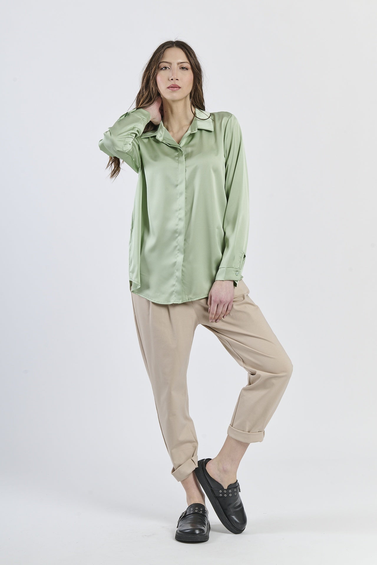 Camicia salvia in seta con colletto, abbinata a pantaloni beige.
