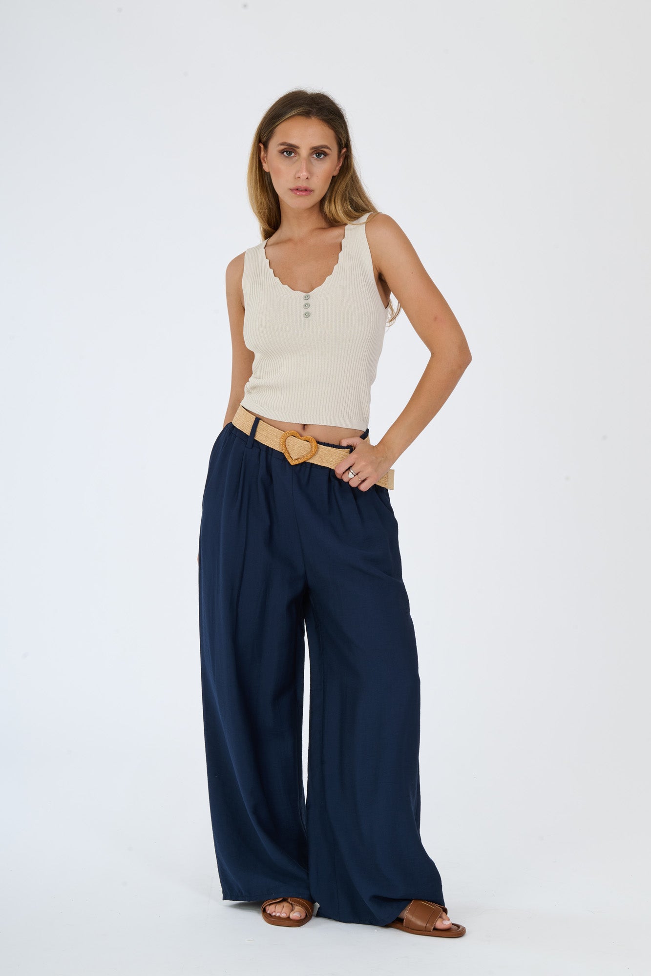 Combinazione di top beige e pantaloni larghi bianchi, ideale per un look estivo e confortevole.