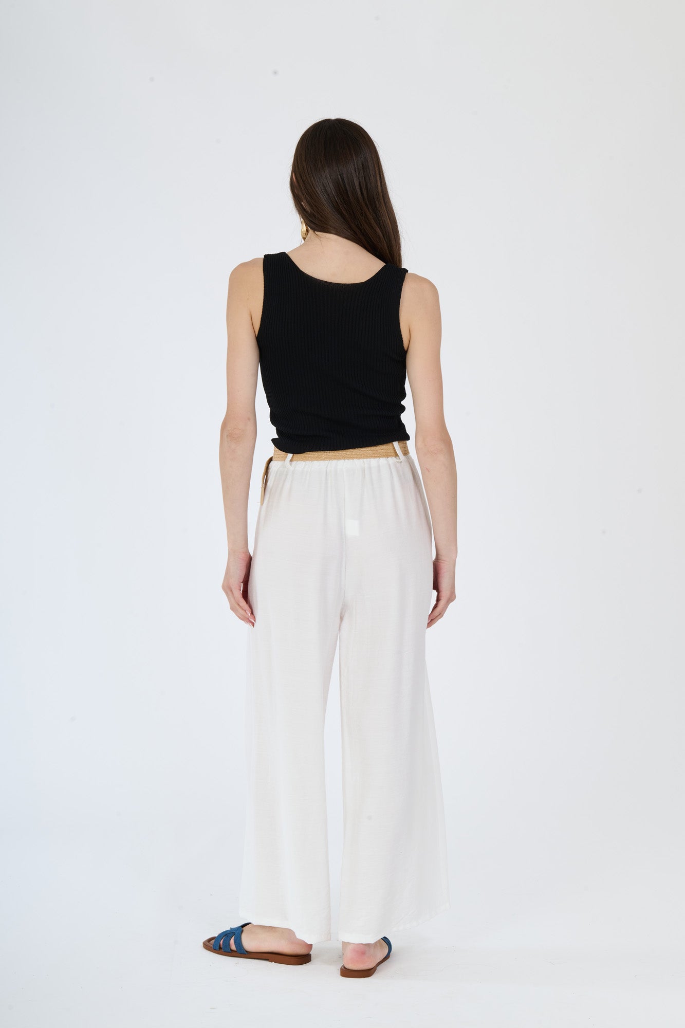 Combinazione di top nero e pantaloni larghi bianchi, ideale per un look dal carattere deciso ed elegante.