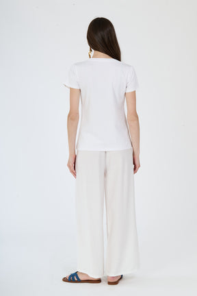 Completo bianco da giorno: t-shirt e pantaloni indossati da una modella