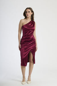 Donna con abito vino a spalla unica, passione e intensità elegante.