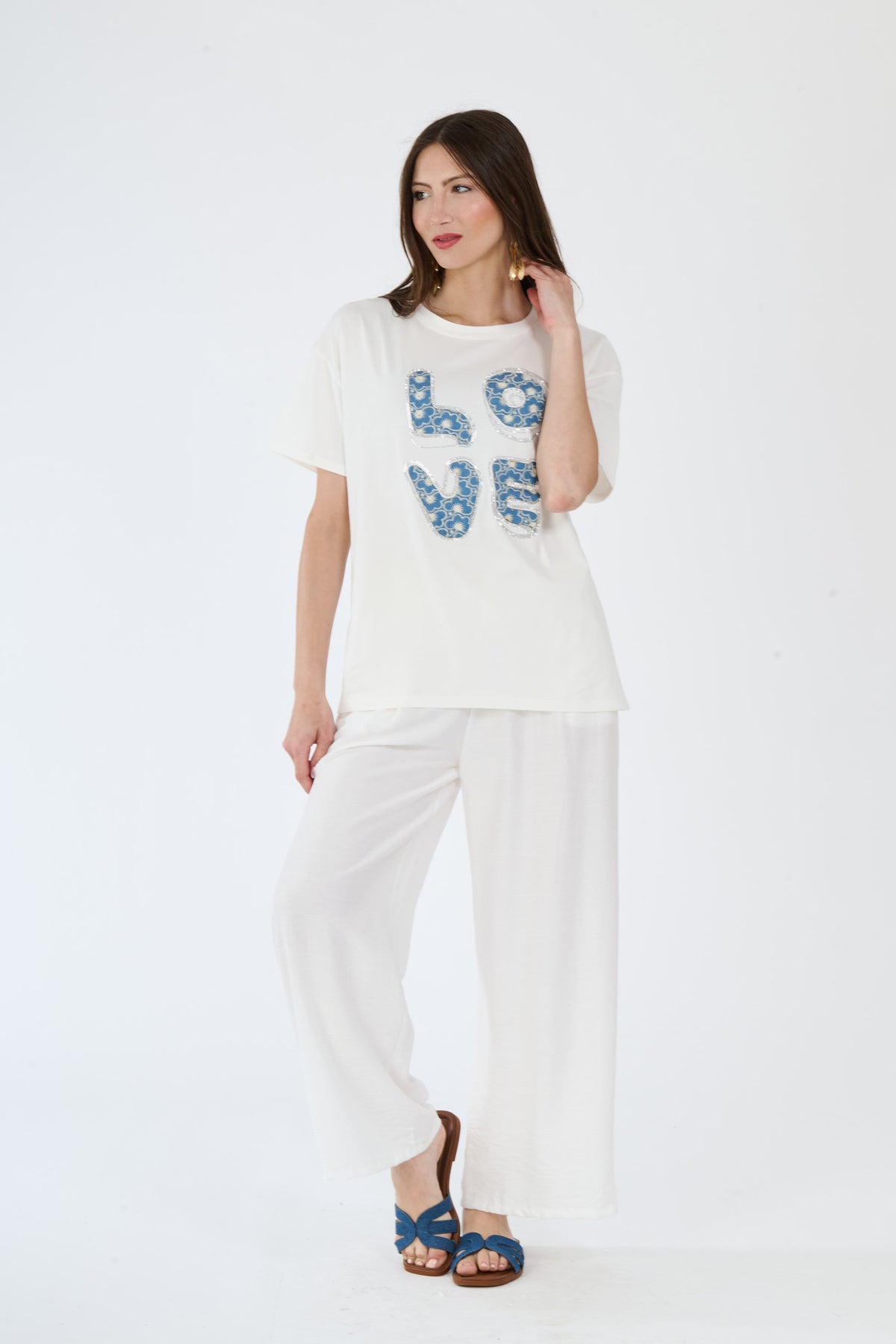 Donna con t-shirt bianco e pantaloni larghi scuri