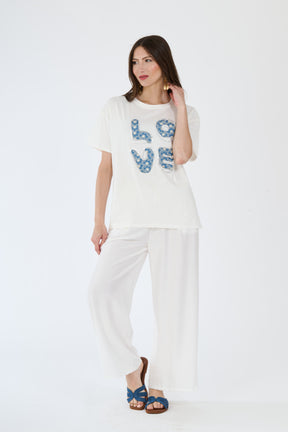 Donna con t-shirt bianco e pantaloni larghi scuri